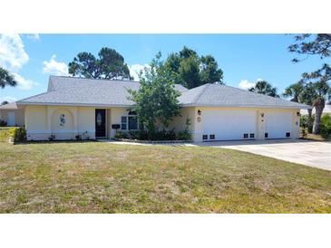 Charming ranch-style home featuring an attached three car garage, fresh landscaping, and a well-maintained lawn at 1351 Washington Dr, Englewood, FL 34224