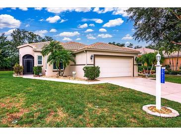 Charming single-story home featuring a tile roof, two-car garage, and well-maintained landscaping at 26111 Feathersound Dr, Punta Gorda, FL 33955