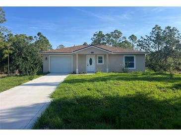 Charming single-story home with a well-manicured lawn and a concrete driveway at 27128 Aloha Dr, Punta Gorda, FL 33955