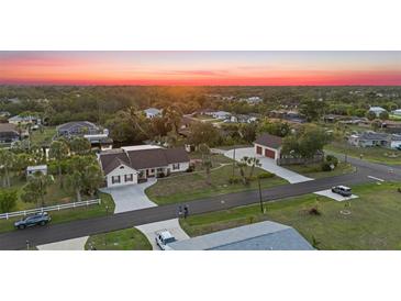 Beautiful aerial view of home with spacious yard, detached garage, and lovely sunset at 4317 Mccullough St, Port Charlotte, FL 33948