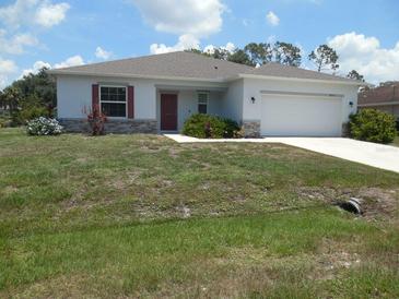 Charming single-story home with a well-maintained lawn, stone accents, and a two-car garage at 4830 Cazes Ave, North Port, FL 34287
