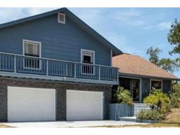 View of home's exterior showcasing the attached garage and landscaped entrance at 6421 Grove Blvd, Punta Gorda, FL 33982