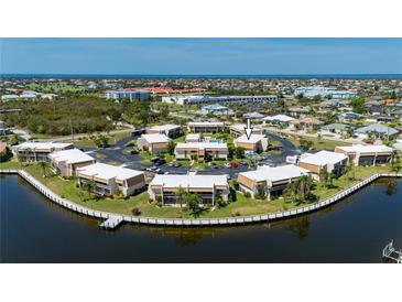 Beautiful aerial view of a waterfront condo complex with a community pool and surrounding landscaping at 1080 Bal Harbor Blvd # 12C, Punta Gorda, FL 33950