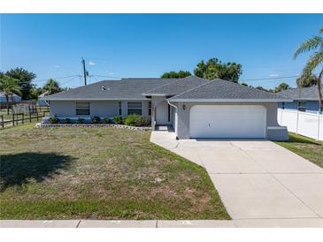 Charming single story home featuring a well-maintained yard, attached two-car garage, and neutral paint scheme at 19468 Edgewater Dr, Port Charlotte, FL 33948