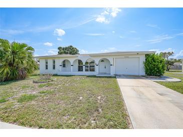 Charming single-story home featuring a well-manicured lawn, arched entryway and attached one car garage at 2166 Beacon Dr, Port Charlotte, FL 33952