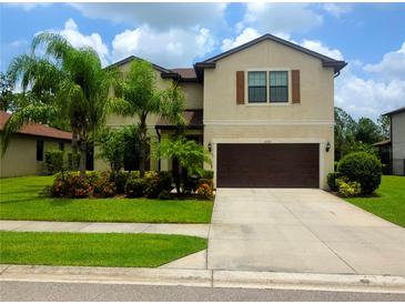 Inviting two-story home with a well-manicured lawn and a two-car garage, perfect for Gathering living at 2739 Sherman Oak Dr, North Port, FL 34289