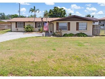 Charming single-story home featuring a well-maintained lawn, palm trees, and an American flag at 315 Holly Rd, Venice, FL 34293