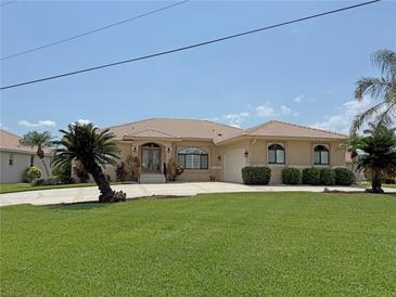 Beautiful single-story home featuring a well-manicured lawn, tiled roof, and an inviting entrance at 3398 Tripoli Blvd, Punta Gorda, FL 33950