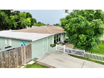 Charming home with a well-maintained yard, white picket fence, and a lovely painted pelican on the shed at 481 Reading Nw St, Port Charlotte, FL 33952