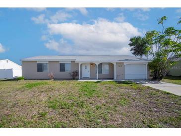 Charming single-story home featuring a well-maintained lawn and attached garage at 6850 S Biscayne Dr, North Port, FL 34287