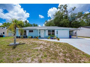 Charming single-story home with a blue exterior, well-kept lawn and white trim around the windows at 7231 Elyton Dr, North Port, FL 34287