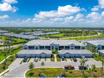Stunning aerial view of a modern condo community with well-maintained landscaping and a picturesque lake at 14257 Heritage Landing Blvd # 1115, Punta Gorda, FL 33955