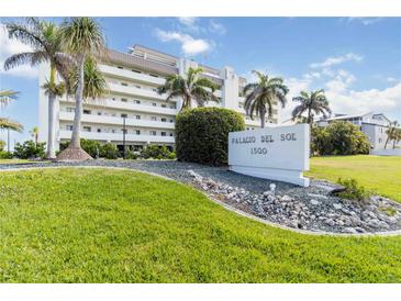Beautiful white building Palacio Del Sol 1500 with tropical landscaping and palm trees at 1500 Park Beach Cir # 5E, Punta Gorda, FL 33950