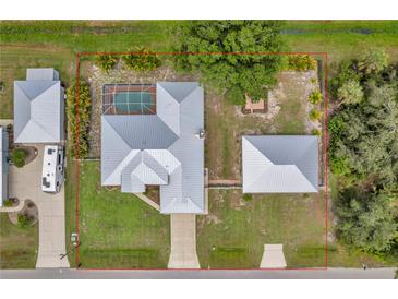 This aerial view showcases a home with a metal roof, an in-ground pool, an oversized lot, and an RV parking area at 1761 Okolona St, North Port, FL 34287
