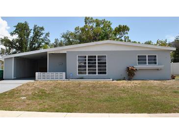 Charming single-story home with a well-maintained lawn and covered parking at 21275 Austin Ave, Port Charlotte, FL 33952