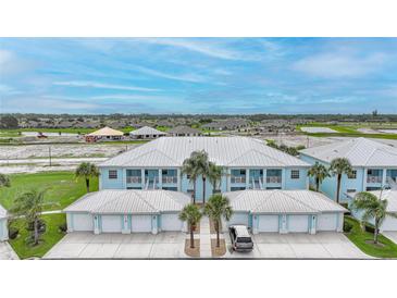 Charming blue condo with a metal roof, garages, and lush landscaping at 5762 Sabal Trace Dr # 203, North Port, FL 34287