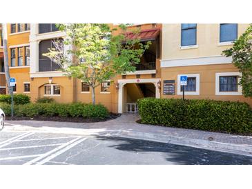 Welcoming entrance with manicured landscaping to a beautiful yellow condo building with stairs and balconies at 99 Vivante Blvd # 310, Punta Gorda, FL 33950