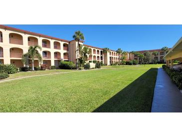Sprawling condominium complex featuring well manicured lawn, lush landscaping and covered balconies at 1 Colony Point Dr # B20, Punta Gorda, FL 33950