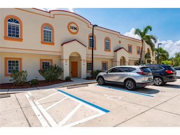 Attractive building exterior featuring multiple units, designated parking and tropical landscaping at 1236 Rio De Janeiro Ave # 406, Punta Gorda, FL 33983