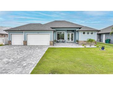 Beautiful single-story home with a three-car garage, well-manicured lawn, and a charming front entry at 15148 Taurus Cir, Port Charlotte, FL 33981
