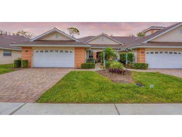 Charming single-story villa boasts an attached garage, manicured landscaping, and a welcoming brick driveway at 2028 Lynx Run, North Port, FL 34288