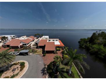 Waterfront home features a charming red tile roof, lush landscaping, and brick-paved drive, with stunning views of the bay at 25188 Marion Ave # 1, Punta Gorda, FL 33950