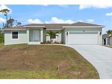 Charming single-story home featuring a two-car garage and well-manicured front yard at 5353 Kaspar St, Port Charlotte, FL 33981