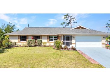 Charming single-story home featuring a well-maintained lawn and an attached two-car garage at 566 Reading Nw St, Port Charlotte, FL 33952