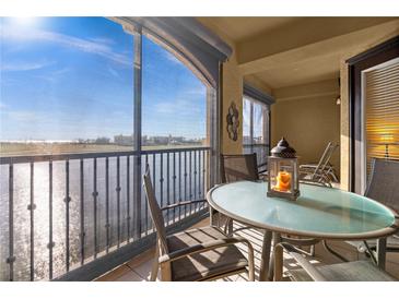Relaxing screened-in balcony featuring a table and chairs with serene views of the water and landscape at 99 Vivante Blvd # 303, Punta Gorda, FL 33950