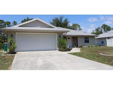 Charming single-Gathering home featuring a two-car garage, metal roof, and well-manicured front lawn at 11422 2Nd Ave, Punta Gorda, FL 33955