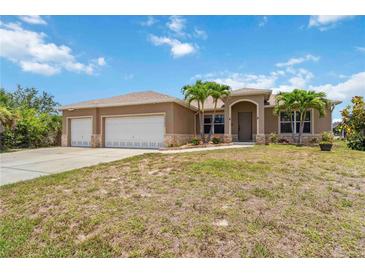 Charming single-story home with well-maintained landscaping and a three-car garage at 15104 Aldama Cir, Port Charlotte, FL 33981