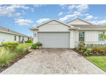 Charming single-Gathering home featuring a two-car garage, paver driveway, and beautifully landscaped front yard at 16965 Hawk Ct, Punta Gorda, FL 33982