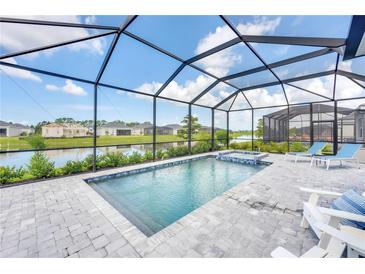 Relaxing pool with a spa overlooking a serene water view, perfect for unwinding after a long day at 17557 Santorini Ct, Venice, FL 34293