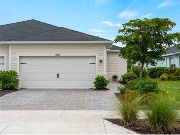 Charming home featuring a two-car garage with brick paver driveway and beautifully landscaped front yard at 17857 Woodland Ct, Punta Gorda, FL 33982