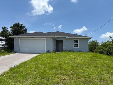 Charming single-story home featuring a two-car garage and a well-maintained lawn at 207 Baytree Dr, Rotonda West, FL 33947