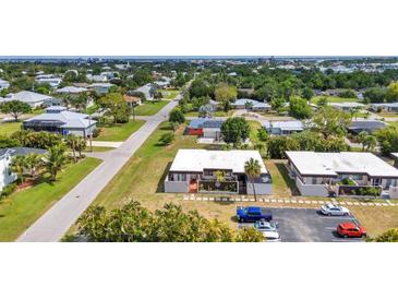 Aerial view of a home in a quiet neighborhood with lush greenery and a well-maintained lawn at 232 W Henry St, Punta Gorda, FL 33950