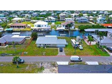 Waterfront home with a metal roof, canal access, and RV/boat parking on a grassy lot, located in a waterfront community at 24239 Yacht Club Blvd, Punta Gorda, FL 33955