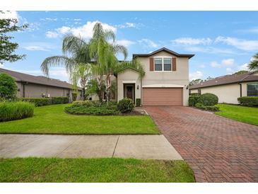 Charming two-story home featuring well-manicured lawn, mature palm trees, and a brick paved driveway at 2515 Sherman Oak Dr, North Port, FL 34289