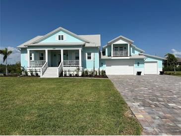 Charming light blue two-story home with a landscaped yard and three-car garage at 3548 Mondovi Ct, Punta Gorda, FL 33950
