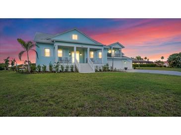 Charming two-story home with a well-manicured lawn and classic architectural details at sunset at 3548 Mondovi Ct, Punta Gorda, FL 33950