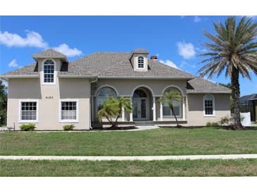 Charming single-Gathering home featuring arched entryways, lush lawn, and mature palm tree at 4150 Enclave Pl, Punta Gorda, FL 33980