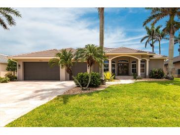 Charming single-story home with a tile roof, well-manicured lawn, and beautiful palm trees in a sunny locale at 523 Saint Girons Ct, Punta Gorda, FL 33950