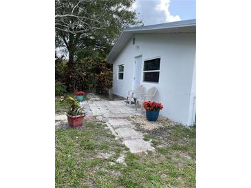 Charming white home with a welcoming walkway and colorful potted plants for a touch of curb appeal at 5727 Beechwood St, Punta Gorda, FL 33982
