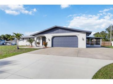 Well-maintained single-story home with a two-car garage and a beautiful, spacious concrete driveway at 711 Forest Hill Nw Ln, Port Charlotte, FL 33948