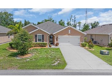 Charming single-story home featuring a well-manicured lawn, covered entry, and attached two-car garage at 7652 Mikasa Dr, Punta Gorda, FL 33950