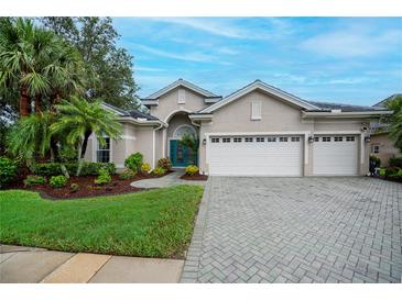 Charming single-story home with a well-manicured lawn, a three-car garage, and a beautiful teal-colored front door at 1062 Eagles Flight Way, North Port, FL 34287
