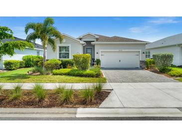Charming single-story home featuring a well-manicured lawn, tropical landscaping, and a paver driveway at 16176 Lotus Way, Punta Gorda, FL 33982