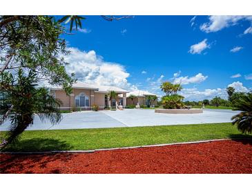 Elegant single-Gathering home with a spacious driveway, lush lawn, and meticulously maintained landscaping at 17400 White Water Ct, Punta Gorda, FL 33982