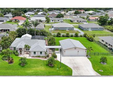 Inviting single-Gathering home with attached two-car garage, luscious lawn and tropical landscaping at 23493 Taber Ave, Port Charlotte, FL 33954
