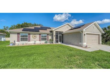 Charming single Gathering home featuring a large front yard, solar panels, and neutral stucco exterior at 237 Strasburg Dr, Port Charlotte, FL 33954